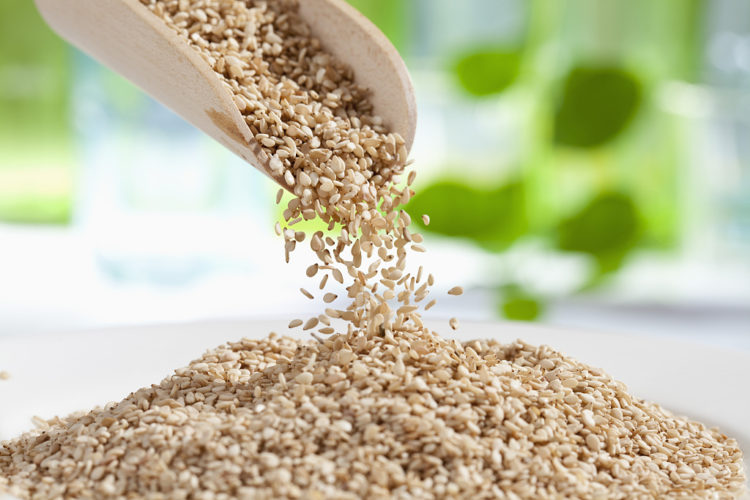 sesame seed (Sesamum indicum),  pooring from wooden shovel