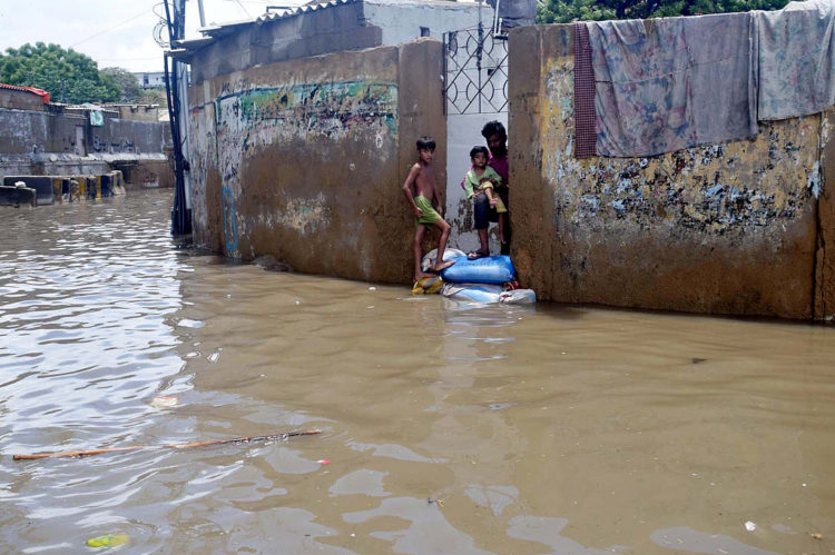 KARACHI, PAKISTAN, JUL 12: View of stagnant rainwater while commuters are facing 
difficulties in transportation causing of poor sewerage system after heavy downpour of monsoon 
on second day of Eid-ul-Azha, at Pakistan Chowk area in Karachi on Tuesday, July 12, 2022. 
Torrential rains caused widespread flooding and damage in the countrys financial capital 
Karachi on Monday, the second day of Eid ul-Azha, even inundating the business district. 
According to the police, five men were killed by electrocution in various areas while one died 
due to a wall collapse. (S.Imran Ali/PPI Images).