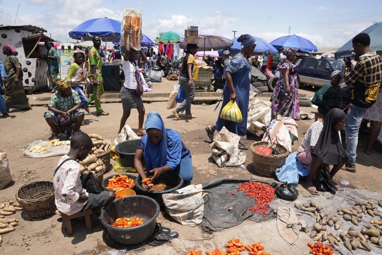 FILE - Pedestrians shop at a street market in Lagos, Nigeria, on Sept. 7, 2022. Nigeria's consumer inflation surged to a 17-year high in August 2022, its statistics agency said on Thursday, Sept. 15, 2022, signalling more hardship for citizens and businesses in Africa's largest economy. (AP Photo/Sunday Alamba, File)