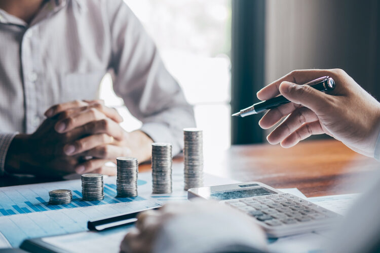Business group brainstorming on meeting to planning project finance analyzing calculate with report document, stacking coins for step up growing business to profit and saving with wealth management.