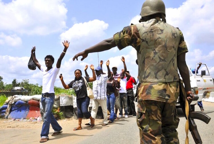 A Nigerian military officer directs civilians at a checkpoint along Sapele-Warr road in the Niger Delta region May 26, 2009. Nigerian security forces repelled an attempted attack on an offshore oil drilling platform operated by French energy company Total on Tuesday, a security contractor working in the oil industry said. Around five attackers in a speedboat exchanged fire with security personnel shortly after dawn close to the platform at Total's 125,000 barrels per day Amenam field, located around 30 km (19 miles) from the coast of the Niger Delta.  REUTERS/Afolabi Sotunde (NIGERIA CONFLICT ENERGY POLITICS BUSINESS CRIME LAW)