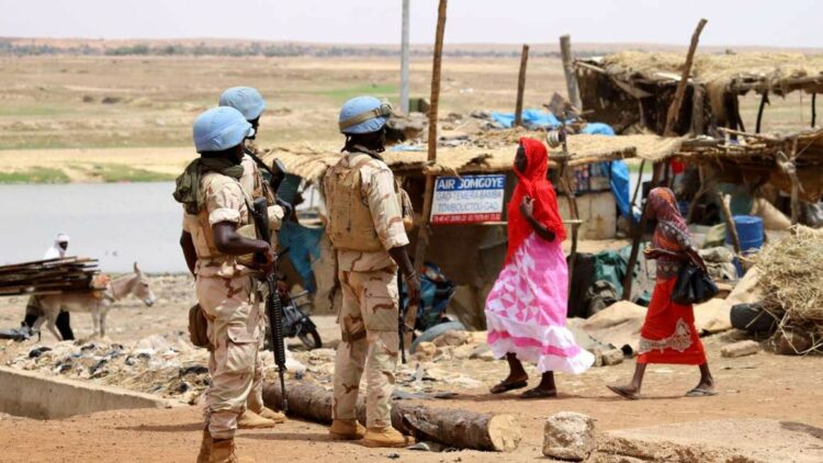 Senegalese soldiers of the UN peacekeeping mission in Mali MINUSMA (United Nations Multidimensional Integrated Stabilisation Mission in Mali) patrol on foot in the streets of Gao, on July 24, 2019, a day after suicide bombers in a vehicle painted with UN markings injured one French, several Estonian troops and two Malian civilians in an attack on an international peace-keeping base in Mali. - Malian authorities have struggled to improve security since France intervened in 2013 to drive back Islamic insurgents in the north. Around 4,000 French troops are deployed under Operation Barkhane alongside the MINUSMA peacekeeping force of around 15,000 soldiers and police. (Photo by Souleymane Ag Anara / AFP)