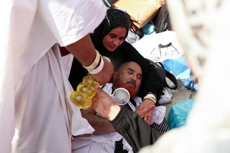 A man effected by the scorching heat is helped by others as Muslim pilgrims arrive to perform the symbolic 'stoning of the devil' ritual as part of the hajj pilgrimage in Mina, near Saudi Arabia's holy city of Mecca, on June 16, 2024. Pilgrims perform the last major ritual of the hajj, the "stoning of the devil", in western Saudi Arabia on June 16, as Muslims the world over celebrate the Eid al-Adha holiday. (Photo by Fadel Senna / AFP)