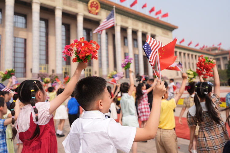 Children waves flowers and American and Chinese flags before President Donald Trump is greeted by Chinese President Xi Jinping at a welcome ceremony at the Great Hall of the People, Thursday, May 14, 2026, in Beijing. (AP Photo/Mark Schiefelbein)